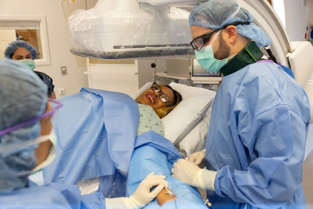 Dr. Astani with patient and team in the operating room preparing for UFE procedure